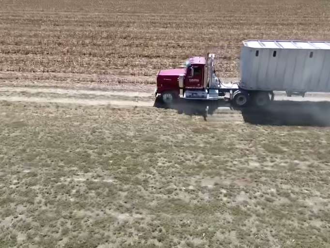 Truck hauling across a field to the job